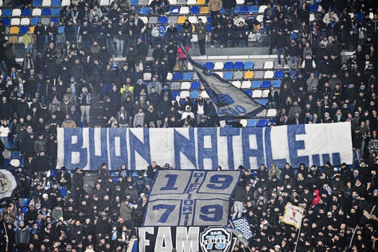 Italian football fans with a banner declaring "Merry Christmas" in Italian